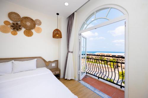 1 dormitorio con 1 cama y balcón en Lily House Hotel Phu Quoc en Phu Quoc