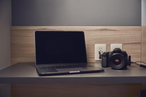 a laptop computer and a camera on a desk at One Acapulco Diamante in Acapulco