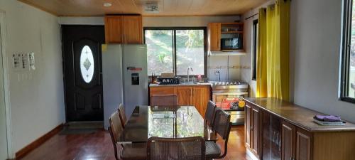 a kitchen with a table and chairs in a room at Tu casa de campo, Menus de la Montaña, te espera in Cerro Azul