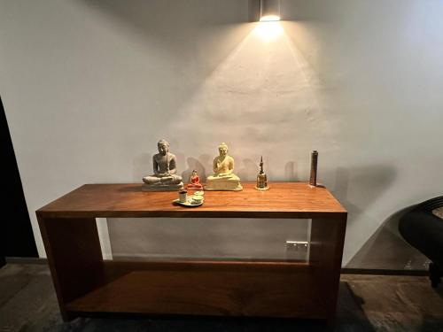 a table with statues on it with a light on it at Colonial Retreat Villa in Talawatugoda