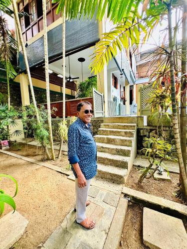 a woman standing in front of a house at Colonial Retreat Villa in Talawatugoda