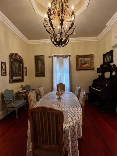 a dining room with a table and a chandelier at El Amador Inn Downtown Tucson in Tucson