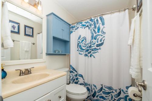 ein Badezimmer mit Waschbecken, Toilette und Duschvorhang in der Unterkunft Jax Vacations 1/2 Mile to Beach, 2 bedroom townhome pet friendly in Jacksonville Beach