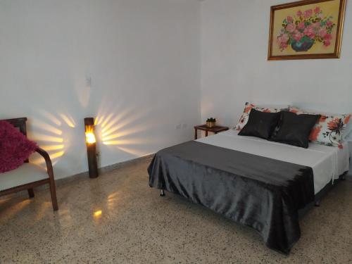 a bedroom with a bed and a chair and a lamp at Casa en Laureles, ideal para familias in Medellín