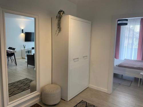 a white cabinet in a room with a bedroom at BALTIC SUN in Sztutowo