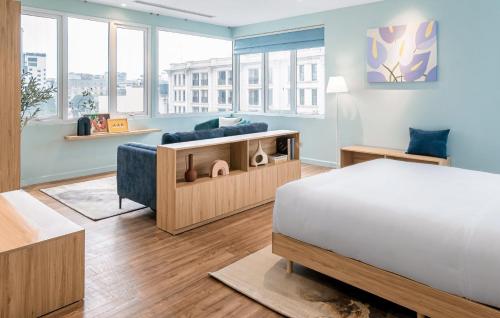 ハノイにあるM Village Hotel Hồ Gươmのベッドとソファのある寝室