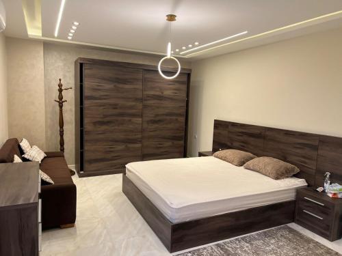 a bedroom with a large bed and a couch at شقة فندقية فاخرة in Al Ma‘şarah