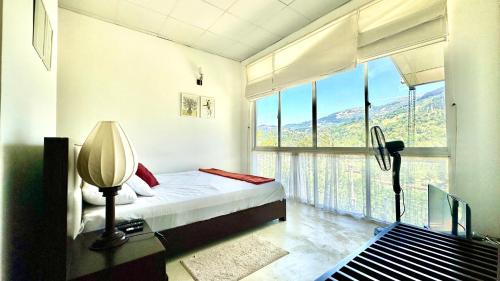 a bedroom with a bed and a large window at Dream Hills Villa, Nillambe Kandy in Kandy