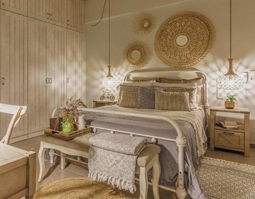 a bedroom with a bed and a bench in it at Villa Salvia - Country style luxury & a captivating poolscape in Áyiai Paraskiaí
