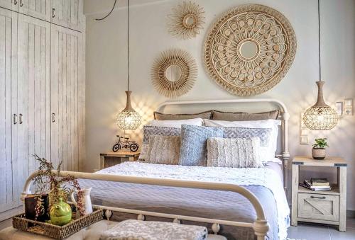1 dormitorio con 1 cama con almohadas azules y blancas en Villa Salvia - Country style luxury & a captivating poolscape, en Áyiai Paraskiaí