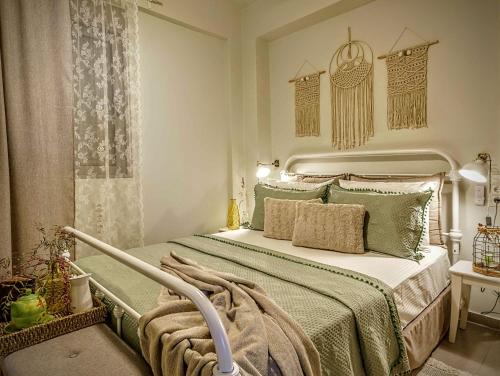 a bedroom with a bed with a green comforter at Villa Salvia - Country style luxury & a captivating poolscape in Áyiai Paraskiaí