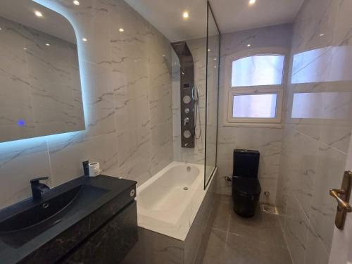 La salle de bains est pourvue d'une baignoire, d'un lavabo et d'une douche. dans l'établissement SHARM el sheikh Villa A7, à Charm el-Cheikh