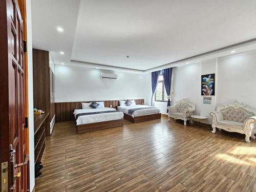 a large room with two beds and two chairs at Hotel Luxstay in Pleiku