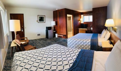 ein Hotelzimmer mit 2 Betten und einem Schreibtisch in der Unterkunft Curly Redwood Lodge in Crescent City