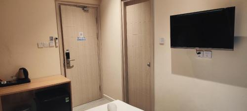 a bathroom with a shower with a television on the wall at The Bok Hotel Grand World - by GoGo Phú Quốc in Phu Quoc