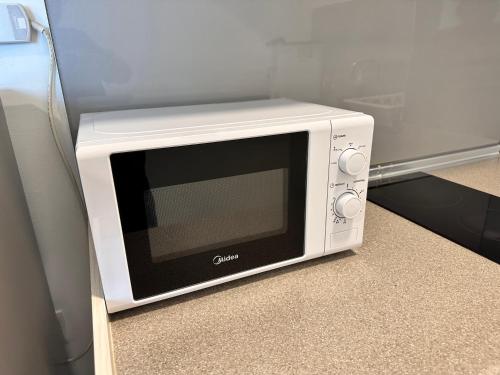a microwave oven sitting on the floor in a kitchen at JQ1 SEA & POOL or CITY View WIFI I WASHING MACHINE for Some Units I CUCKOO WATER Jesselton Quay by R2 in Kota Kinabalu