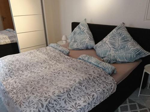 a bed with blue and white pillows on it at Rednak Modern Retreat in Polch