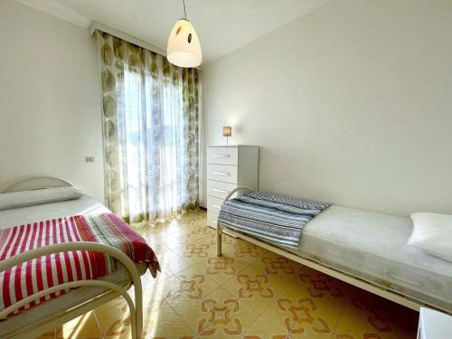 een slaapkamer met een bed, een dressoir en een raam bij Property in Porto Santa Margherita VE in Porto Santa Margherita di Caorle