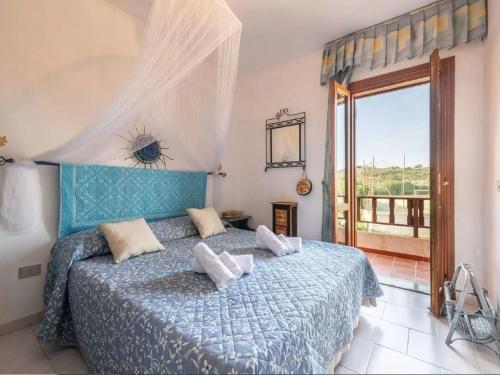 1 dormitorio con cama azul y balcón en Property in Stintino SS, en Villa Sirena