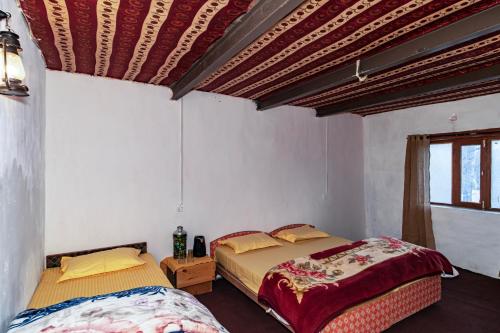 1 Schlafzimmer mit 2 Betten und einem Fenster in der Unterkunft NotOnMap Deshek Homestay Kibber in Kibar