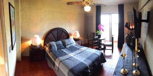 Schlafzimmer mit einem Bett mit blauer Decke in der Unterkunft Aurora Suites in Guadalajara