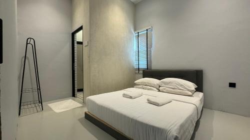 1 dormitorio con 1 cama con sábanas y almohadas blancas en Zen Retreat Glass Pool Villa, en Kamunting