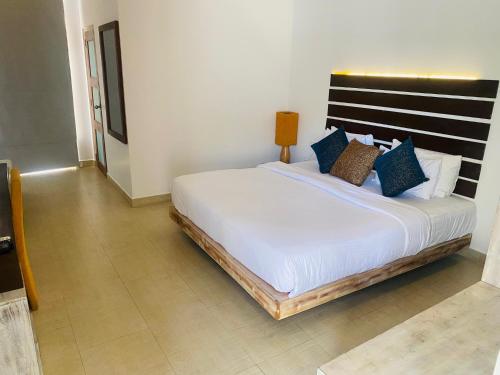a bedroom with a large white bed with blue pillows at Hotel Cloud 9 Negombo in Negombo