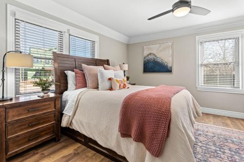 a bedroom with a bed and a dresser and windows at Villa Bella elegant family retreat in downtown in Bentonville
