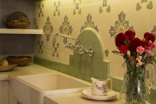 a kitchen with a sink and a vase of flowers at Cielo Arriba Casa in Humahuaca