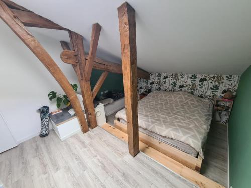 Ce lit se trouve dans un dortoir doté de poutres apparentes. dans l'établissement Ecovilla landaise, à Saint-Laurent-de-Gosse