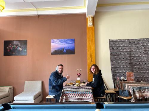 a man and woman sitting at a table in a room at NiNi Homestay Sapa in Sa Pa