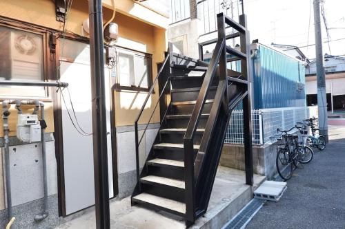 een trap naar een gebouw met fietsen bij TSUBAME 202 staying private home in Osaka