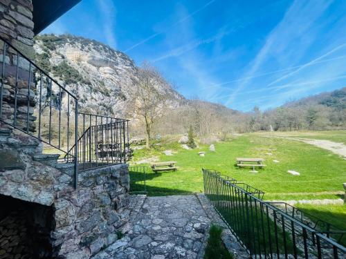 a stone building with stairs and benches in a field at Maso Mandrea in Arco