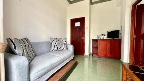 ein Wohnzimmer mit einem Sofa und einem TV in der Unterkunft Royal Pearl Hills in Nuwara Eliya