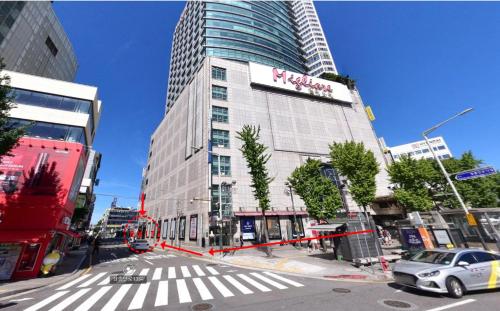 une rue de la ville avec un grand bâtiment et un bus dans l'établissement Hotel Migliore Seoul, à Séoul