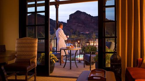a man standing on a balcony looking out at the mountain at Omni Scottsdale Resort & Spa at Montelucia in Scottsdale