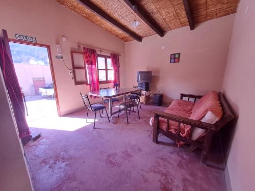 Habitación con cama, mesa y sillas. en ILLARI en Maimará