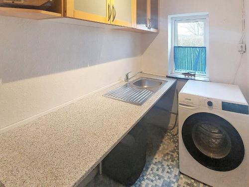 eine Küche mit einer Waschmaschine und einem Waschbecken in der Unterkunft Holiday home Skjern XXI in Skjern