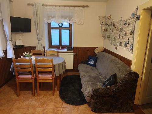 uma sala de estar com um sofá e uma mesa em Naše chalupa em Stará Červená Voda