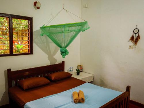 a bedroom with a bed with a green net at The White House in Trincomalee