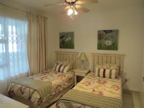 1 dormitorio con 2 camas y ventilador de techo en 5 Manaba Breeze, en Margate