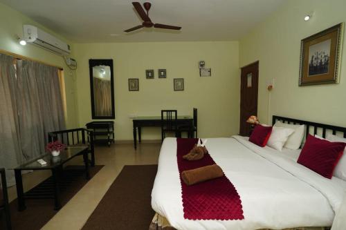 a bedroom with a large white bed with red pillows at Four Seasons Guesthouse in Utorda