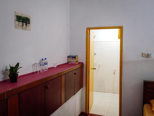 a bathroom with a counter and a door to a shower at The White House in Trincomalee