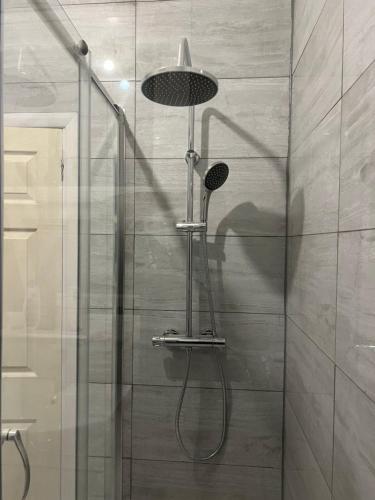 a shower with a shower head in a bathroom at **Dream Home** Near Seaside (Southend on Sea) in Southend-on-Sea