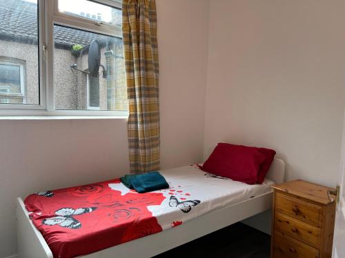 a small bed in a room with a window at **Dream Home** Near Seaside (Southend on Sea) in Southend-on-Sea