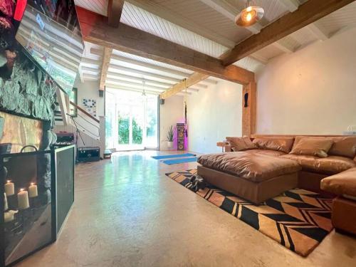 a living room with a couch and a flat screen tv at Sauna + Spa @ Boho House on Bowen Island in Bowen Island