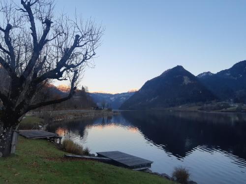 vistas a un lago con montañas en el fondo en Appartements direkt am See, en Grundlsee