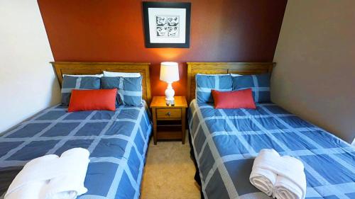 - 2 lits dans une chambre avec des oreillers bleus et rouges dans l'établissement Lucaya Village Resort 3 Bedroom Vacation Home 1503, à Kissimmee