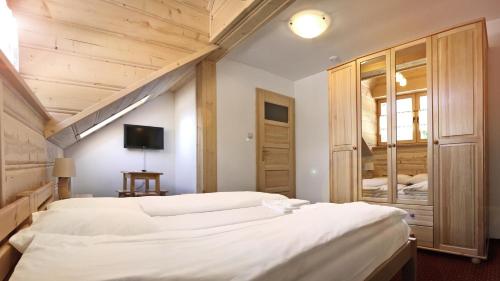 a bedroom with two white beds and a tv at Pensjonat Karczma Spalska in Spała