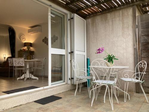 d'une terrasse avec une table, des chaises et une table. dans l'établissement Maison à 5 min à pied du centre ville de Porto-Vecchio, à Porto-Vecchio